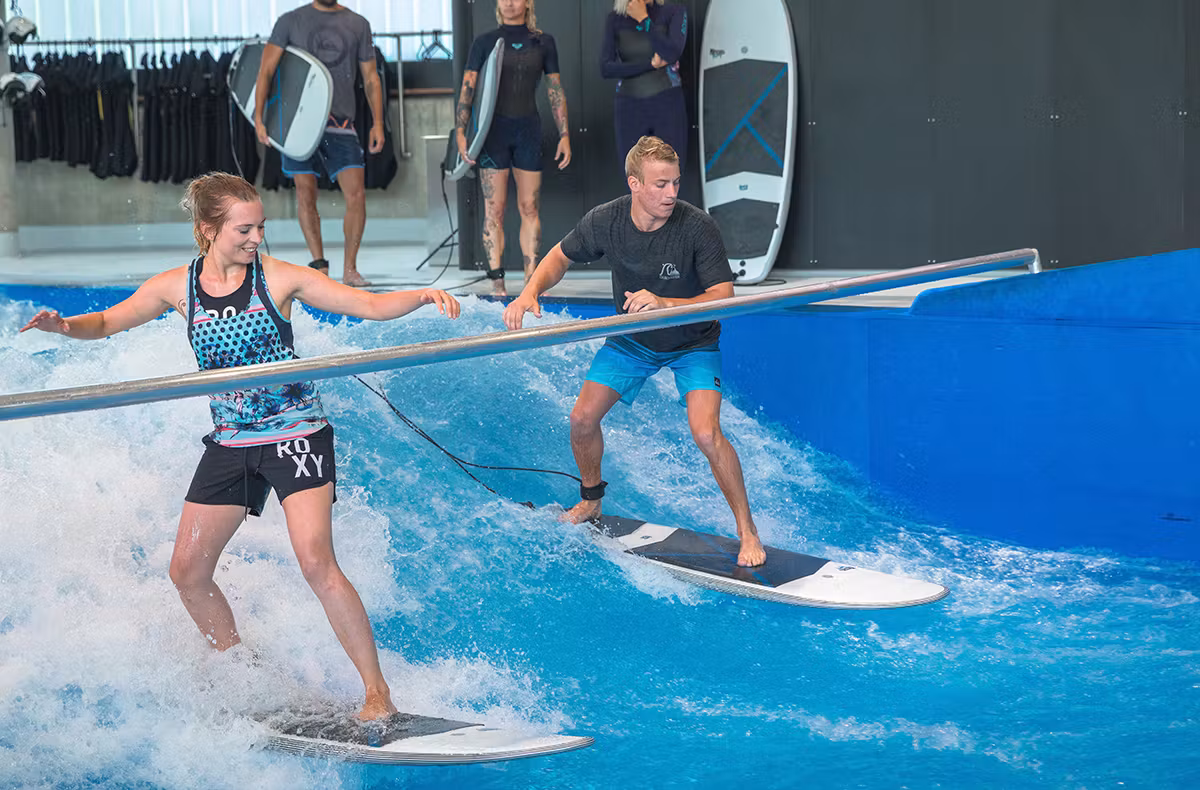 Anfänger beim Indoor Surfen auf einer künstlichen Welle